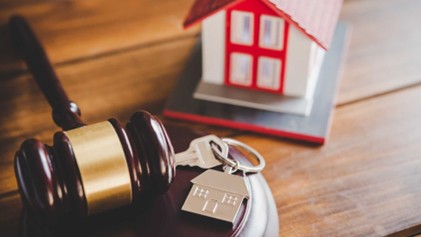 a gavel, a home figurine, and a key